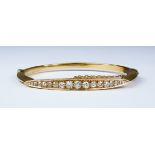 A Diamond Stiff Bangle, 20th Century, yellow metal set with seventeen small brilliant cut