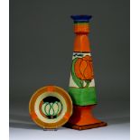 Lily, a Clarice Cliff Fantasque Octagonal Candlestick and Circular Ashtray, the candlestick with