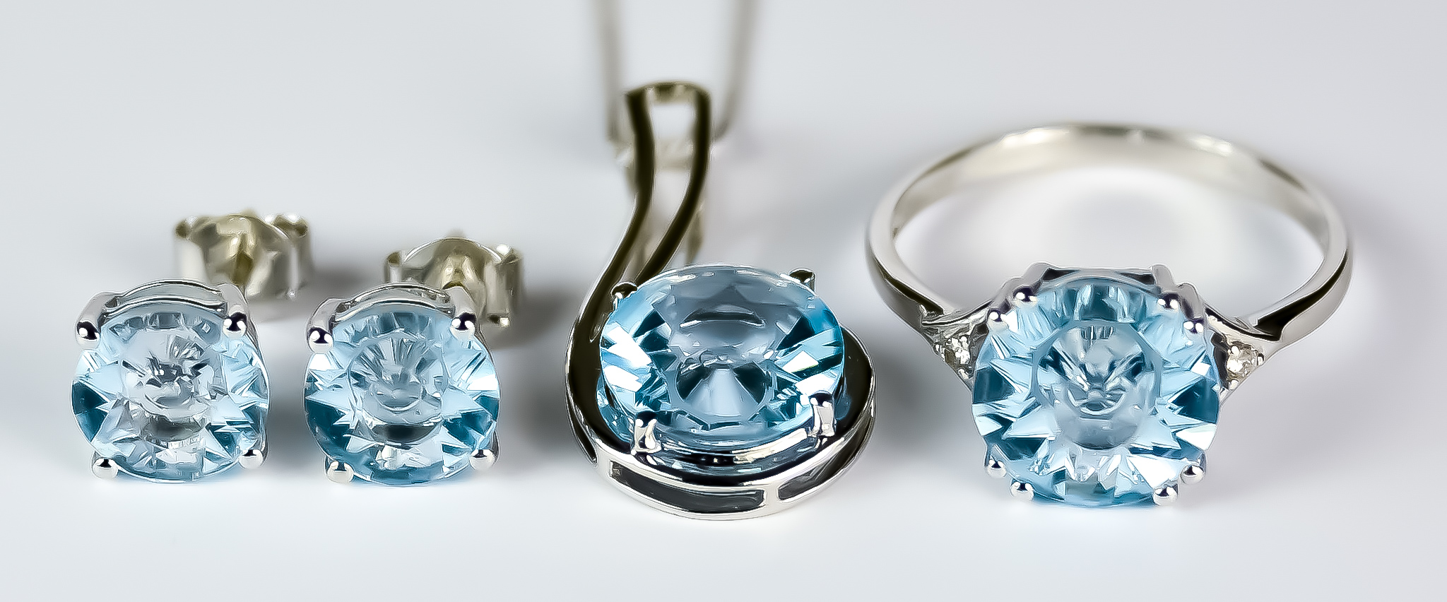 A Blue Topaz Suite, Modern, 9ct white gold ring set with a centre faceted blue topaz stone,