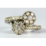 A Diamond Cross Over Flower Head Ring, Modern, 18ct white gold set with small brilliant cut white