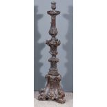 A Continental Carved Oak Pricket Candlestick of Triangular Form, carved with leaf scroll and shell