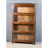 An Early 20th Century Oak Four-Tier Sectional Bookcase, each tier with a glazed rising fall front,