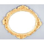 A Modern Gilt Framed Oval Wall Mirror, the frame carved with floral and leaf scroll ornament, and