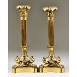 A Pair of Cast Gilt Brass Pillar Candlesticks of Empire Design, the triangular base and paw feet