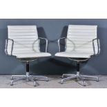 After Charles Eames (1907-1978) - A Pair of Chrome Framed Swivel Armchairs, upholstered in cream