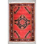 A 20th Century Anatolian Rug of Persian Design, woven in colours with a bold stylised floral