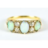 An Opal and Diamond Ring, 20th Century, set with three cabochon opals interspaced by four small