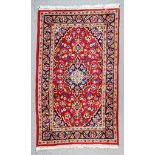 A Mid 20th Century Kashan Rug, woven in colours of ivory, navy blue and wine, with a central