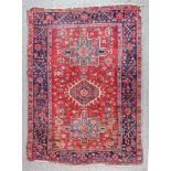 An Early 20th Century Karajeh Rug woven in colours of ivory, navy blue and wine with a central