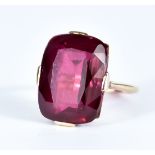 A Ruby Dress Ring, 20th Century, yellow metal mount set with a large faceted synthetic ruby,