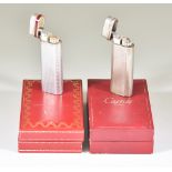 Two Cigarette Lighters by Cartier of Paris, Serial No. 96038V and E01847, silvery metal, both in