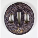A Japanese Iron Tsuba, carved with two dragons amid clouds, with details picked out in gold,