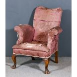 An Early 20th Century Easy Chair of Georgain Design, with shaped back and out-scroll arms,