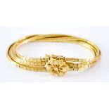 An 18ct Gold Four Strand Flower Head Bracelet, Modern, set with three small diamonds, 170mm overall,