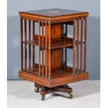 An Edwardian Figured Mahogany Two Tier Revolving Bookcase, the top inlaid with circular fan motif to