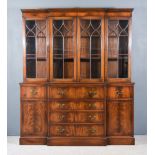 A Mahogany Breakfront Secretaire Bookcase of 'Georgian' Design, the upper part with moulded cornice,