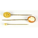 Three Stick Pins, yellow metal, one with carved cameo bust, one set with small gem stone and one