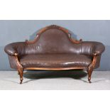 A Victorian Walnut Framed Settee, the shaped and moulded back with scroll carved cresting, curved