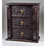 A Miniature Oak Wellington Chest, Late 19th Century, fitted three drawers, the surface carved with