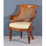 A William IV Mahogany Framed Bergere Armchair with scroll carved crest rail, leaf capped outscrolled