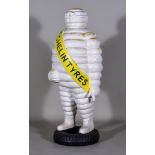 A French Cast Iron Michelin Man Advertising Figure Standing on a Tyre, with yellow sash, 23ins high