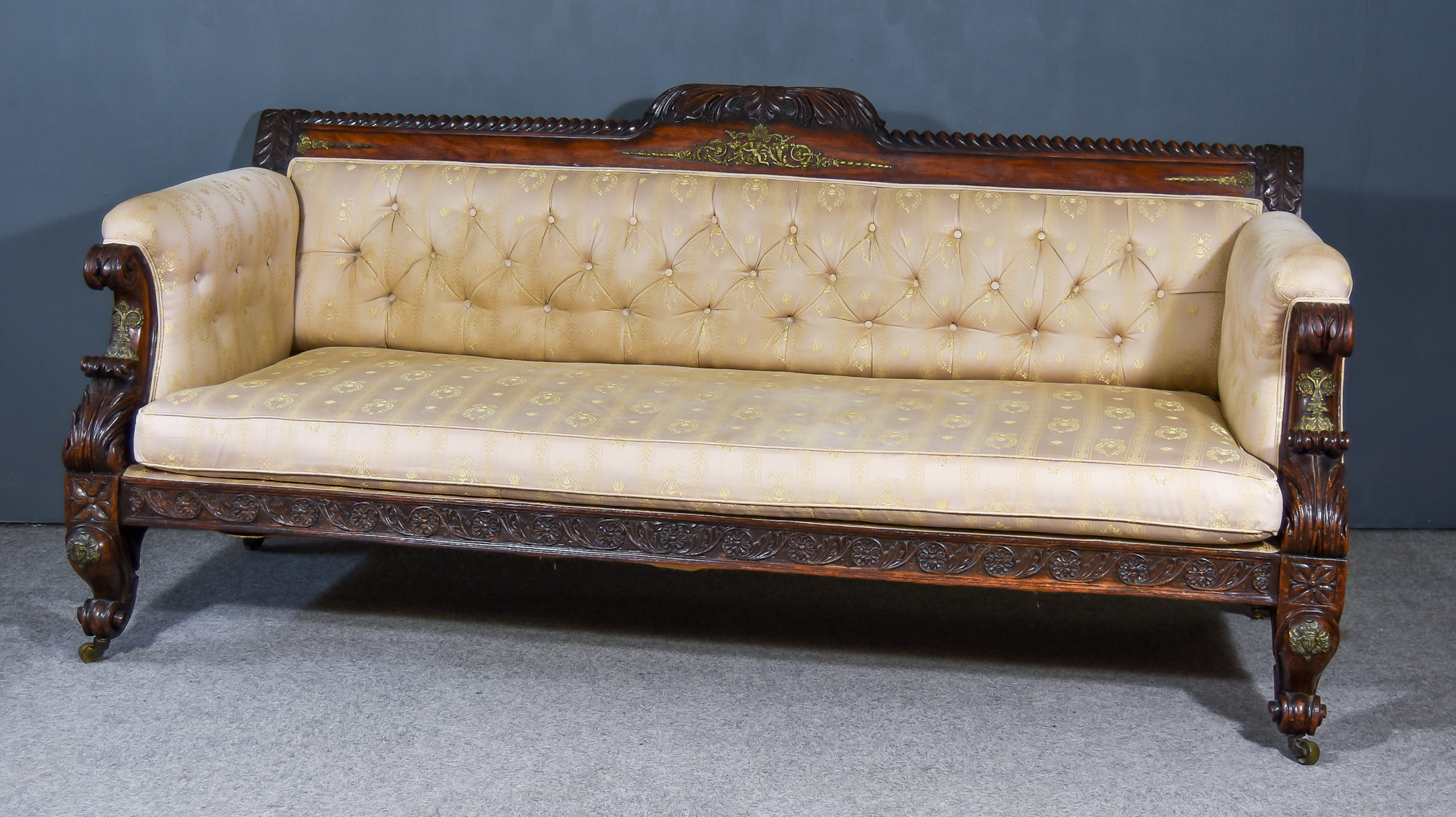 A Regency Rosewood and Gilt Brass Mounted Settee, the shaped crest rail with carved leaf centre