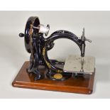 A Willcox and Gibbs Sewing Machine, on wooden base, 13ins x 8.25ins, contained in wooden case and