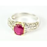 A Ruby and Diamond Ring, Modern, in 14ct white gold mount, set with a central faceted ruby,