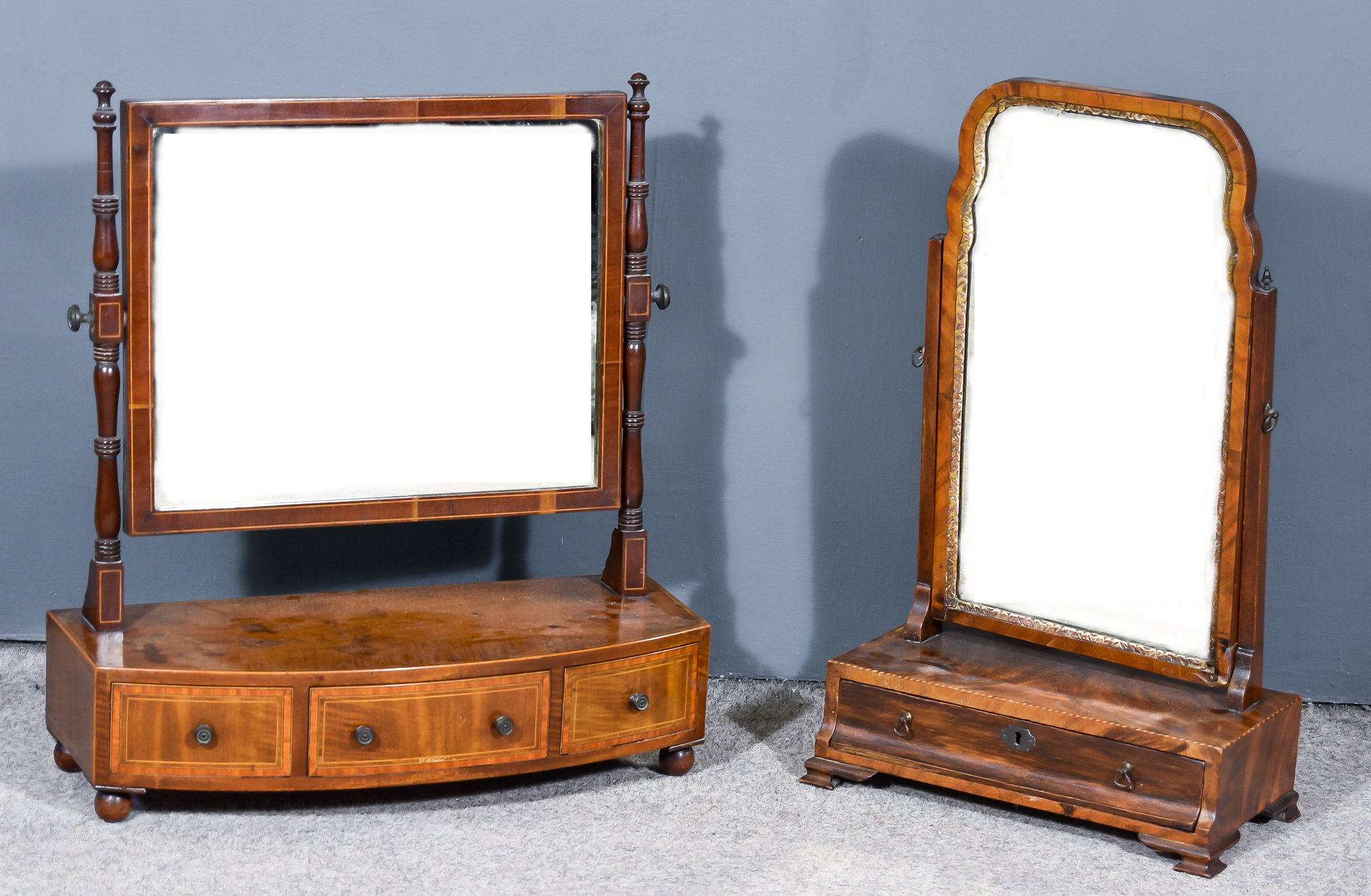 A George III Figured Mahogany Toilet Mirror, on turned uprights, the bow front base inlaid with