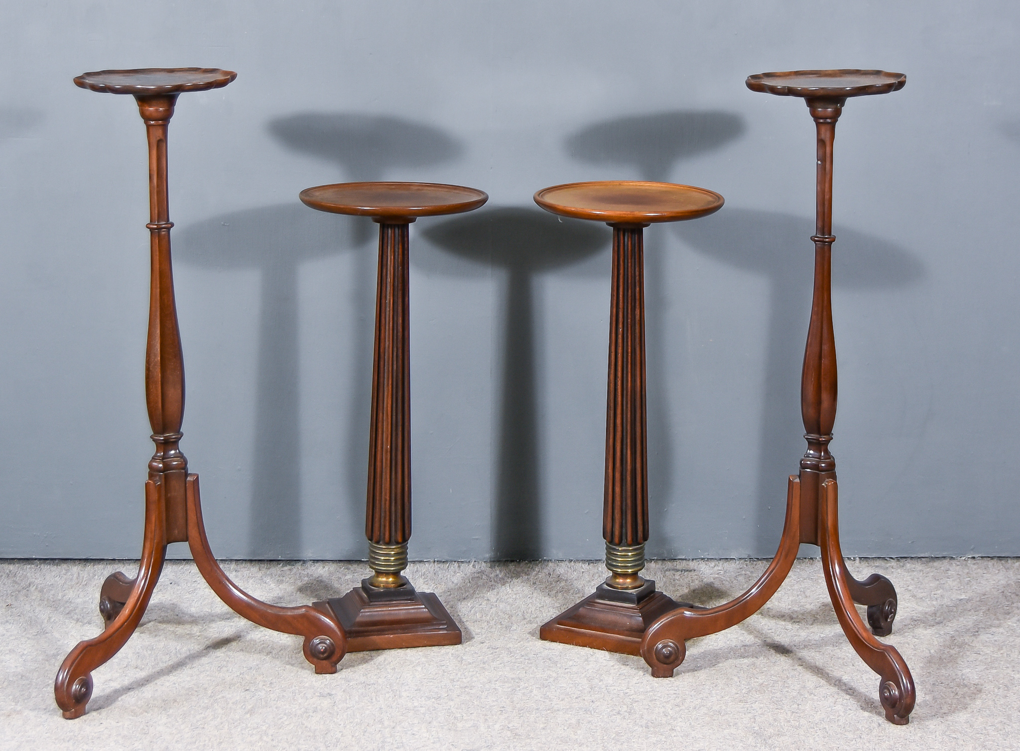 Two Pairs of Mahogany Circular Torcheres, one pair with shaped rims, on slender hexagonal baluster