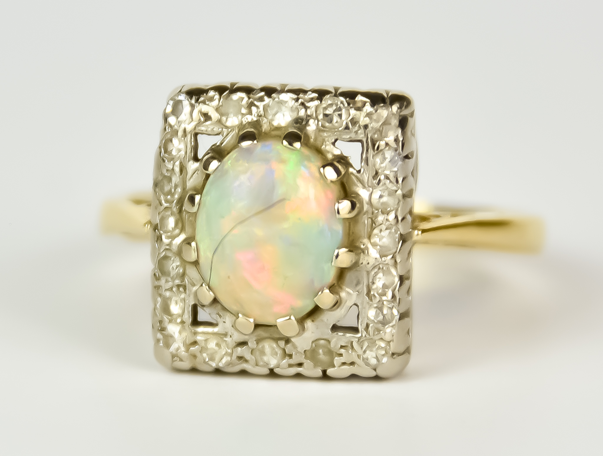 An 18ct Gold and Platinum Opal and Diamond Ring, Modern, centre opal, 10mm x7mm, surrounded by