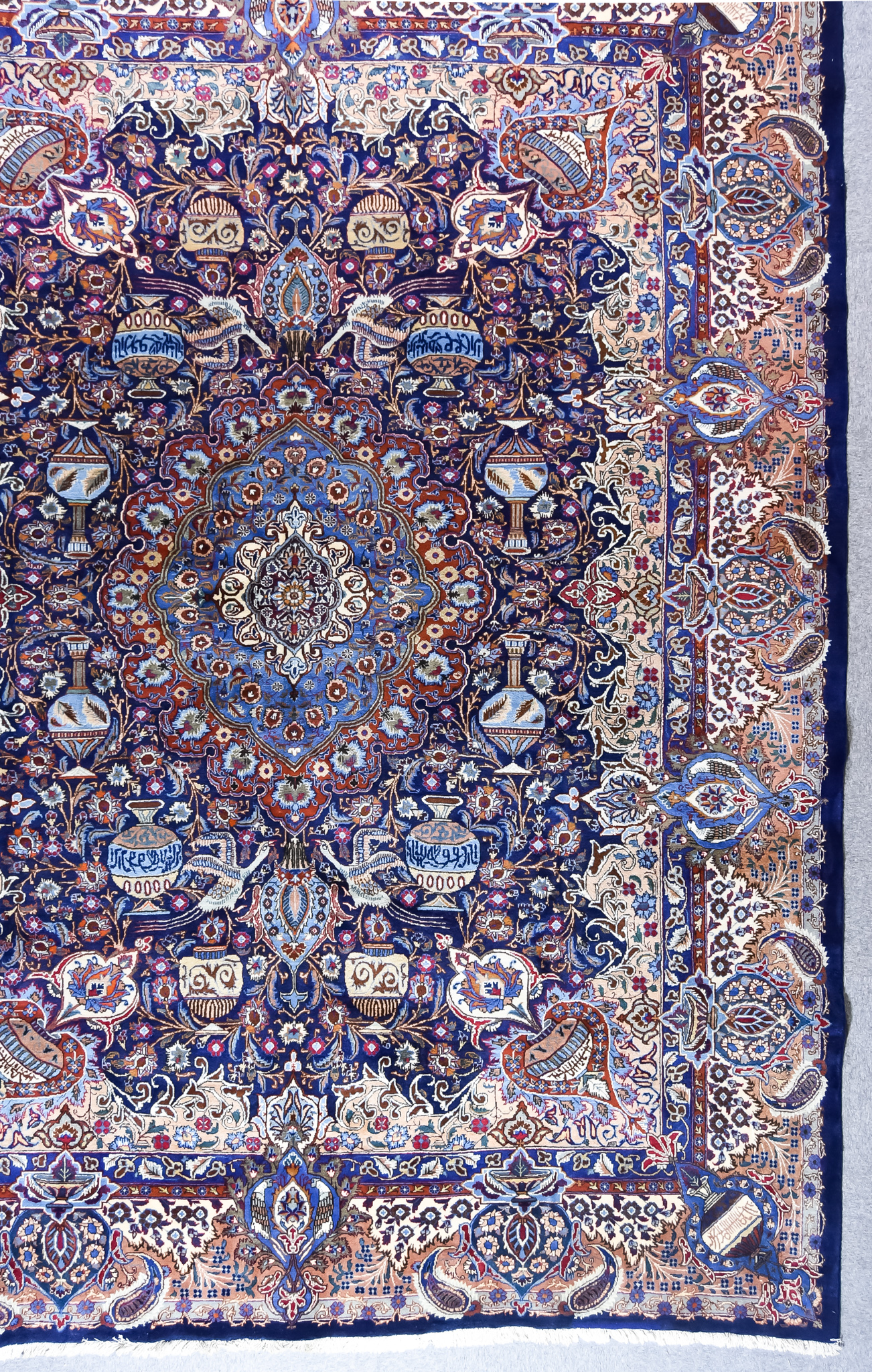 A 20th Century Kashan Carpet, woven in colours of ivory, navy blue, fawn and wine, with a bold