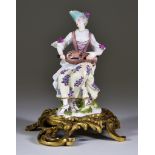 A Meissen Figure, Circa 1745-50, of Columbine playing the hurdy-gurdy, possibly by Eberlein after
