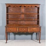 An Old Oak Dresser of "18th Century" Design, the upper part with moulded cornice and shaped