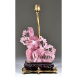 A Chinese Pink Agate Carved Figure of the Seated Guanyin, on pierced wood base, mounted with gilt