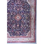 A 20th Century Sarugh Carpet, woven in colours of ivory, navy blue and wine, with a central stylised