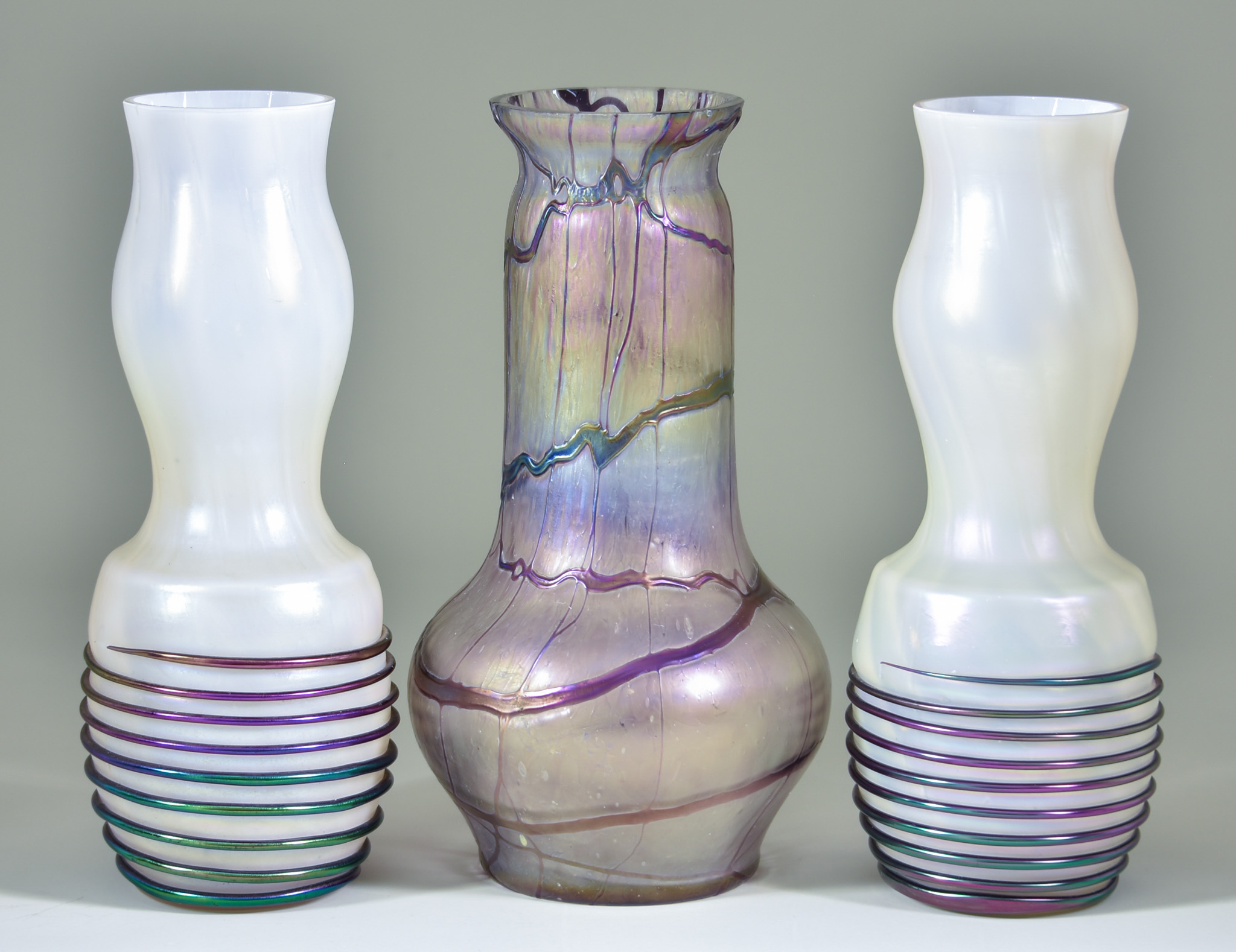 A Pair of Mother of Pearl Iridescent Glass Vases, the bulbous bases with multicoloured iridescent