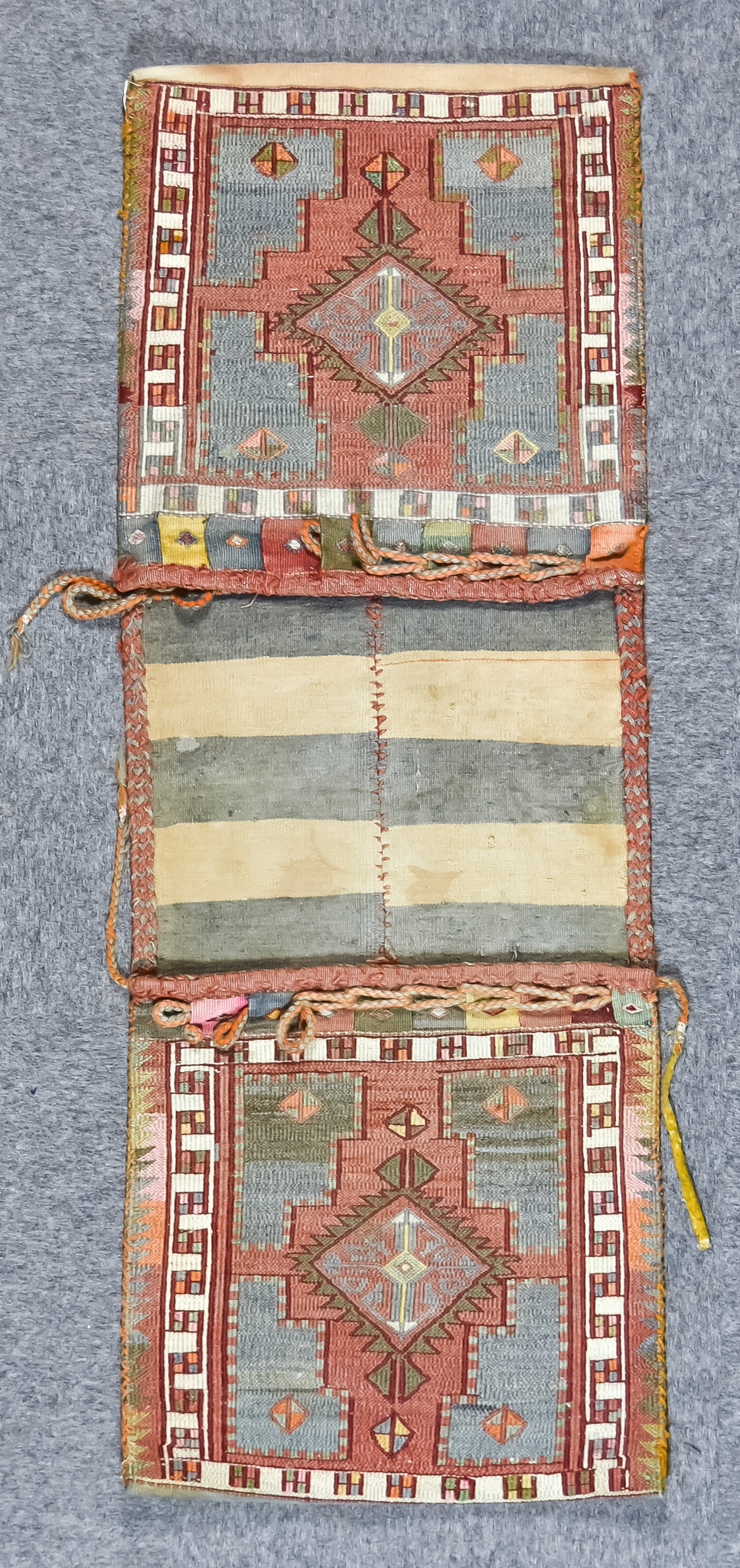 A 20th Century Turkemen Saddle Bag, woven in pastel colours, each panel with hooked pole medallion