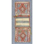 A 20th Century Turkemen Saddle Bag, woven in pastel colours, each panel with hooked pole medallion