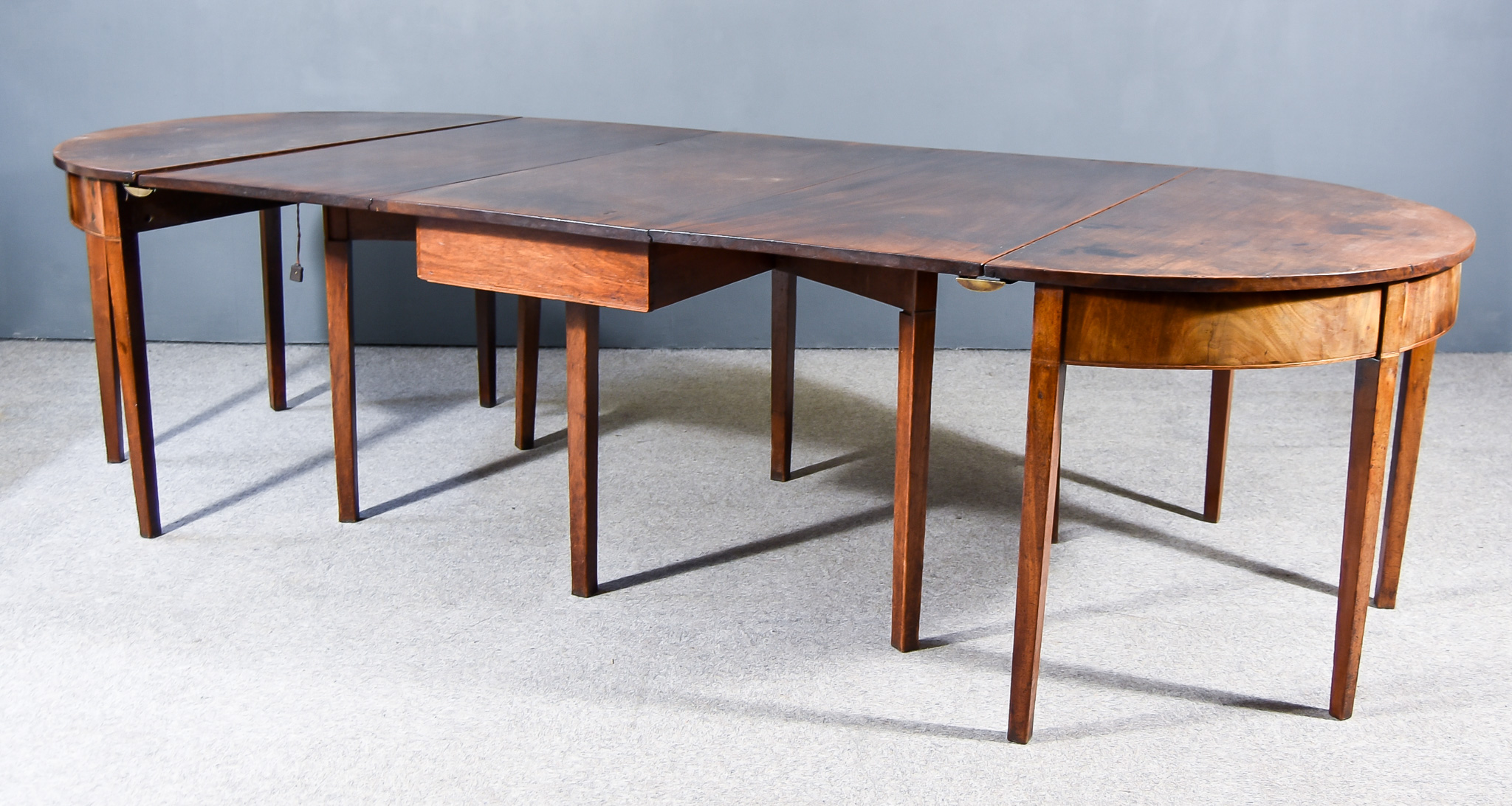 A George III Mahogany Extending Dining Table, on square tapered legs, comprising two D-end