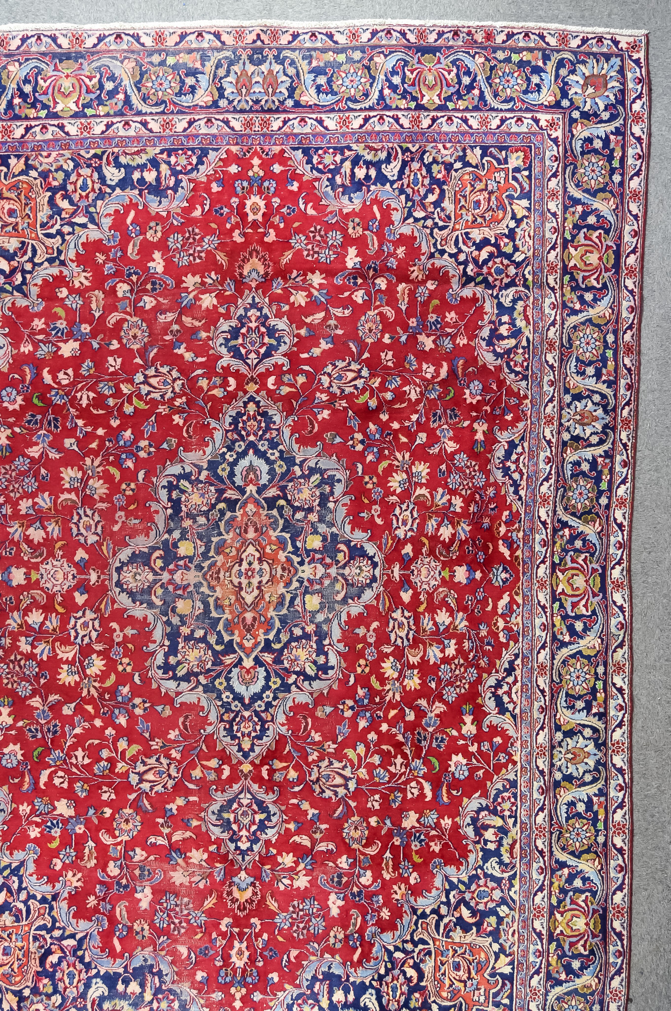 A 20th Century Tabriz Carpet, woven in colours of ivory, navy blue and wine, with a bold stylised