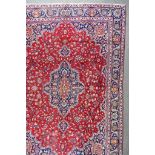 A 20th Century Tabriz Carpet, woven in colours of ivory, navy blue and wine, with a bold stylised