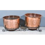 Two Copper Coppers on Wrought Iron Stands, Victorian, one 21.5ins diameter x 18ins high overall, the