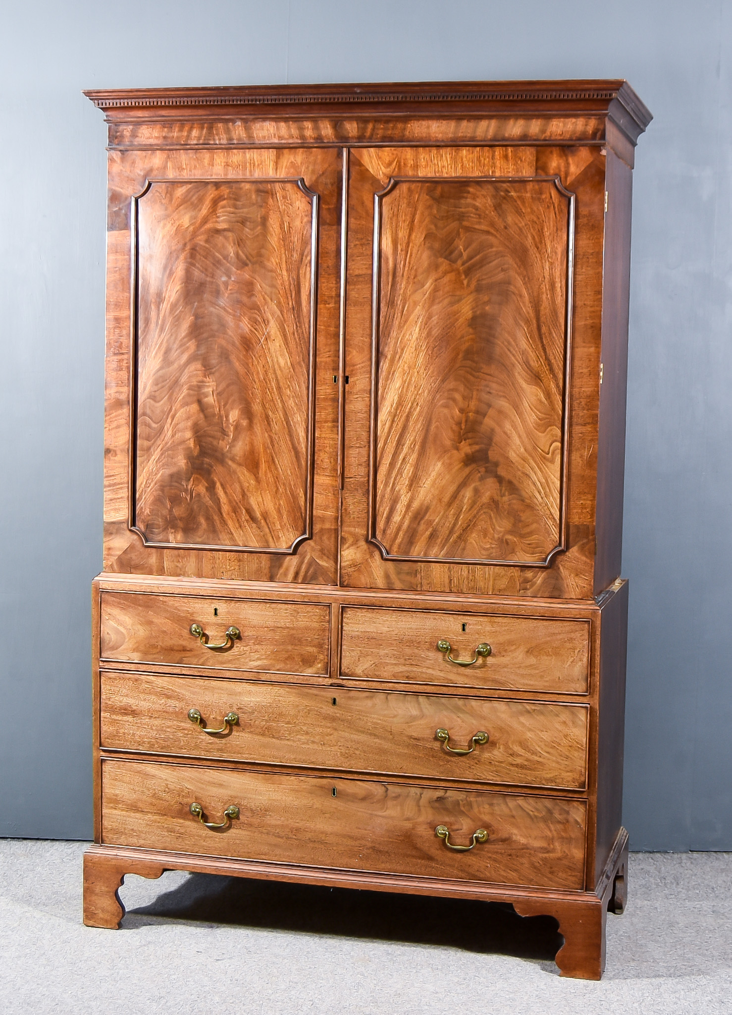 A George III Gentlemen's Mahogany Wardrobe, the upper part with moulded dentil cornice, fitted