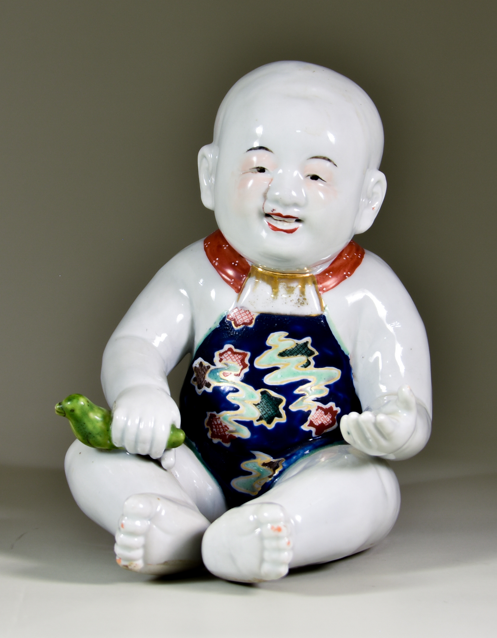 A Chinese Porcelain Figure of a Seated Baby Boy, 7.75ins (19.7cm) high