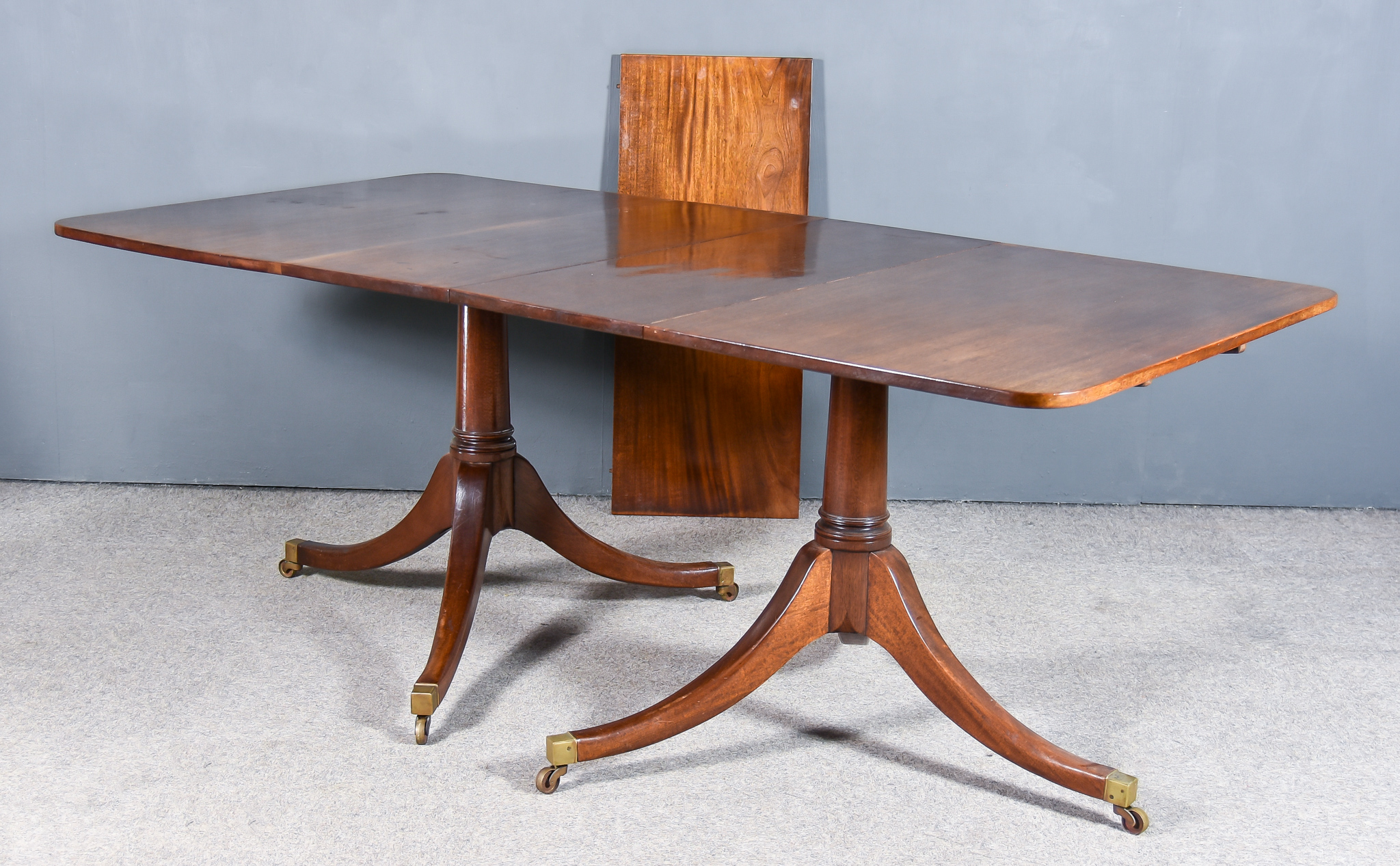 A Mahogany Twin Pedestal Extending Dining Table in the "Georgian" Manner, with two extra leaves