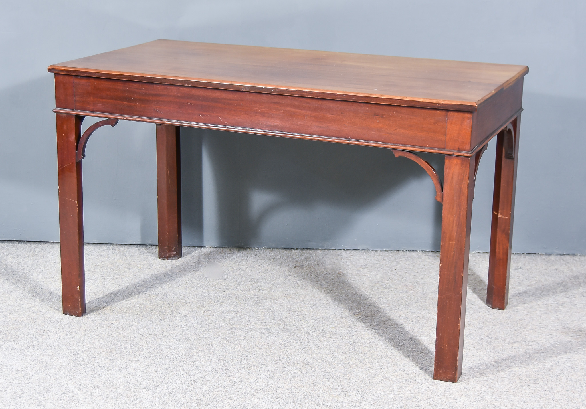 A Mahogany Rectangular Side Table of Georgian Design, with carved edge to top, plain apron on square