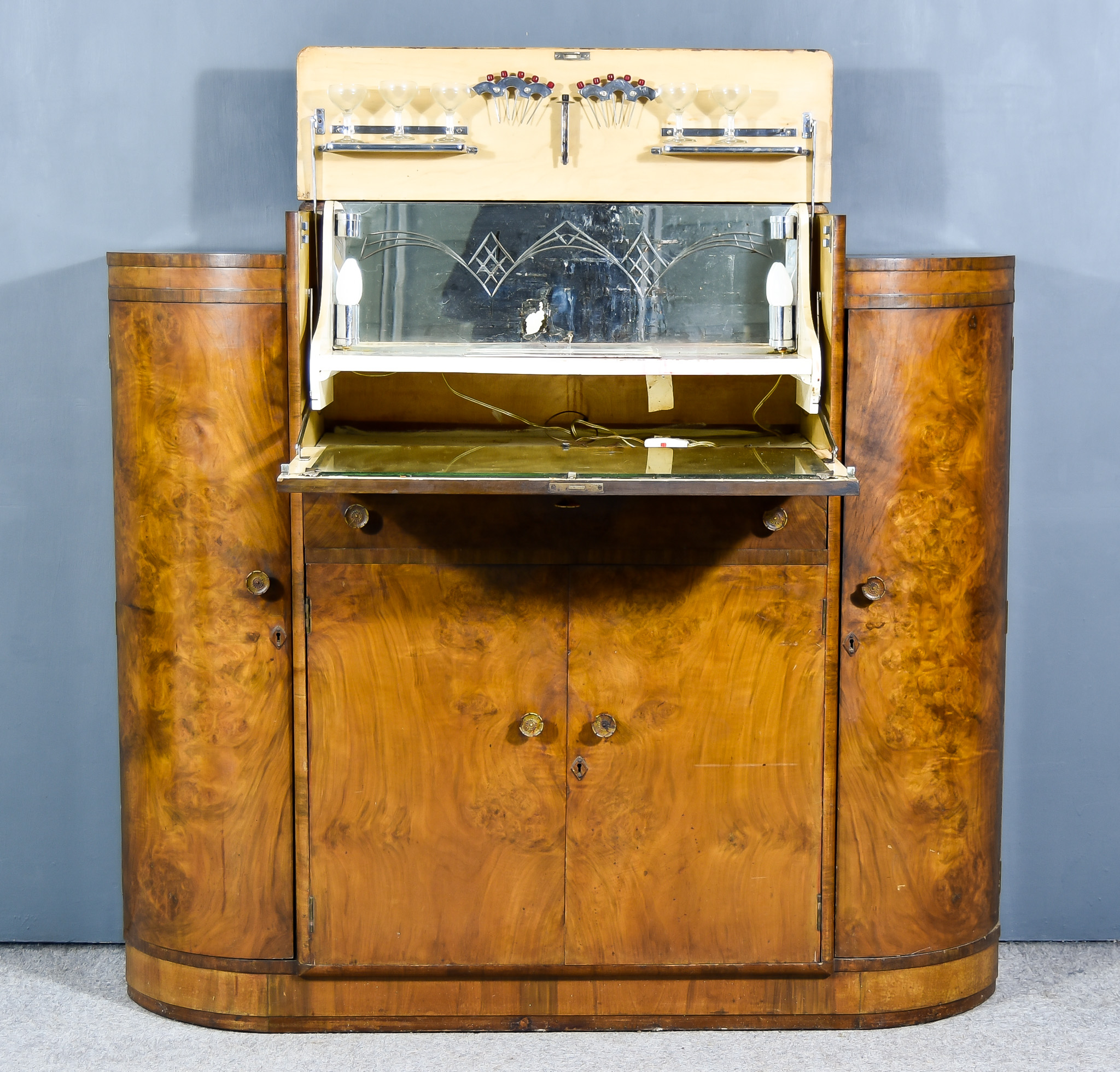 A 1930s Figured Walnut Break Front Cocktail Cabinet of Art Deco Design, the central rising top and