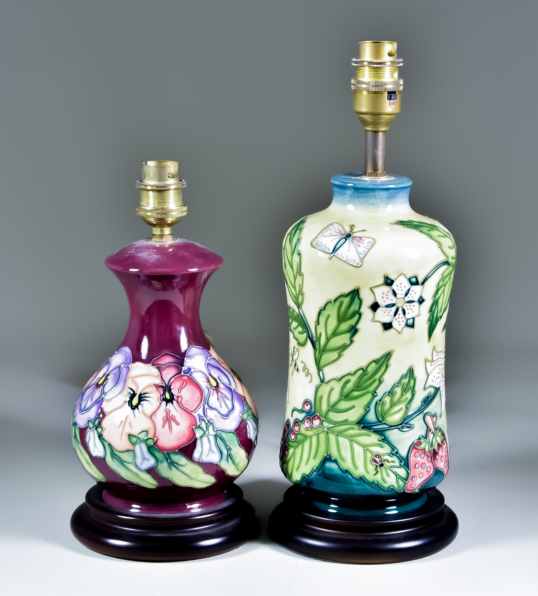 Two Moorcroft Pottery Table Lamps on Wooden Bases, one decorated in Fruit Garden design on a cream