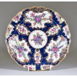 A Worcester Plate, Circa 1765, of shaped outline, enamelled in colours with a blue scale ground,